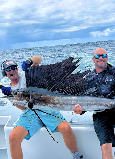 Two enthusiastic anglers show off a nice sailfish before releasing it into the Atlantic.