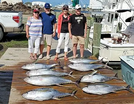 Group of charter customers standing with a great catch of Outer Banks tuna.